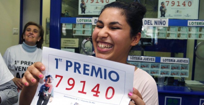 Una joven sostiene el décimo premiado en la Lotería de Navidad de 2015. / EFE