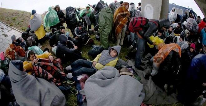 Los migrantes tratan de calentarse bajo la autopista camino de la frontera con Croacia, cerca de Pecinci, a 50 kilómetros de Belgrado. EFE/EPA/KOCA SULEJMANOVIC