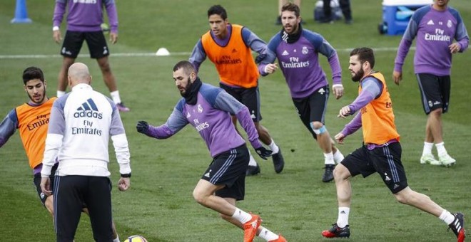 El entrenador del Real Madrid, Zinedine Zidane (2i), da instrucciones a los jugadores durante el entrenamiento previo al partido contra el Atlético. /EFE