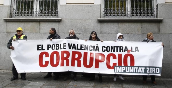 Un grupo de personas con una pancarta alusiva a la corrupción en las inmediaciones del Tribunal Supremo donde la senadora y exalcaldesa de Valencia por el PP, Rita Barberá, ha acudido para declarar voluntariamente como investigada o imputada por un delito