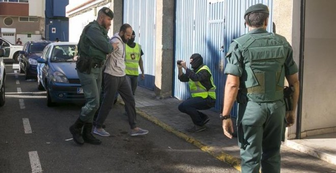 El presunto yihadista detenido hoy en el Aeropuerto de Barajas, es trasladado por agentes de la Guardia Civil a su vivienda en Vecindario. /EFE