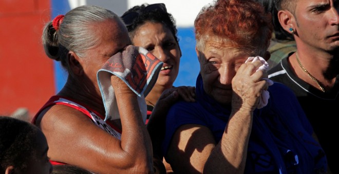 Reacciones de la gente mientras observa el vehículo militar que transporta las cenizas de Fidel Castro. REUTERS