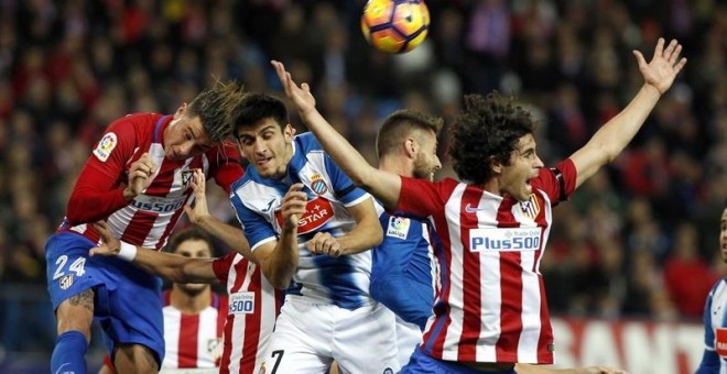 El jugador del Espanyol Gerard Moreno salta a por un balón entre Giménez y Tiago Cardoso, del Atlético. - EFE