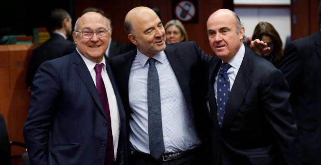 De izquierda a derecha, el ministro de Finanzas francés, Michel Sapin, el comisario europeo de Asuntos Económicos, Pierre Moscovici y el ministro Luis De Guindos. | FRANÇOIS LENOIR (REUTERS)