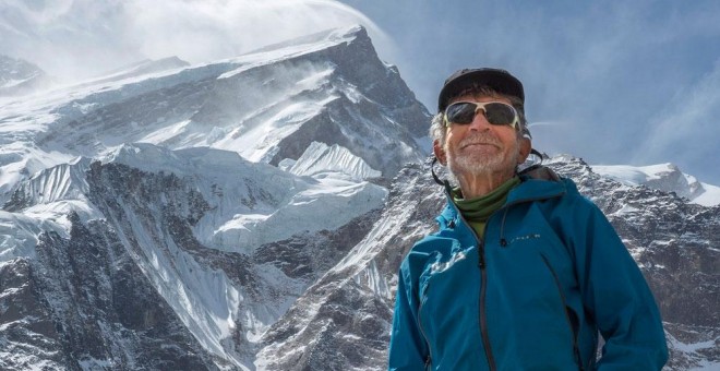 Carlos Soria con el Annapurna de fondo y los fuertes vientos en su cumbre.