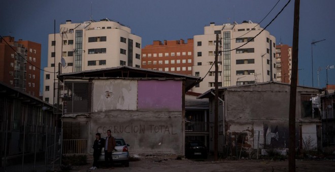 Dos personas en un solar del barrio de la UVA de Hortaleza junto a una pintada. REPORTAJE FOTOGRÁFICO: JAIRO VARGAS