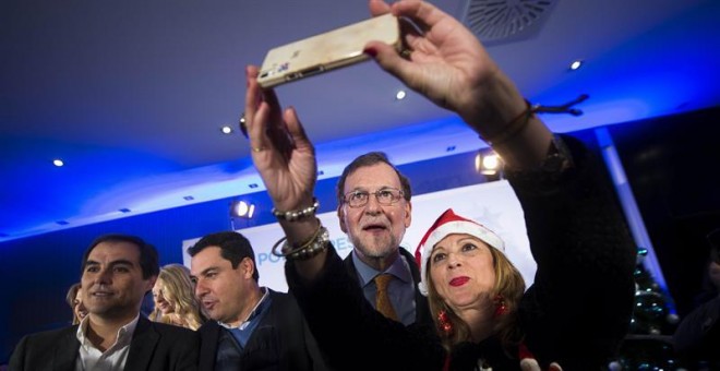 Mariano Rajoy (2d) posa para una foto junto al presidente del PP andaluz, Juanma Moreno (2i), y el presidente del PP de Córdoba y secretario de Estado de Seguridad, José Antonio Nieto (i), durante la tradicional Copa de Navidad del PP de Córdoba. EFE