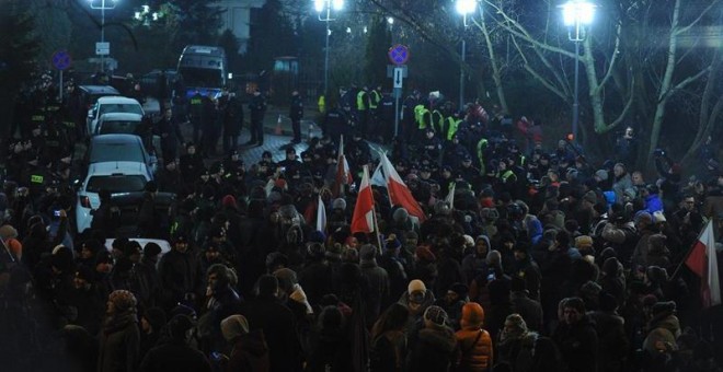 Los manifestantes bloquean la salida del Parlamento polaco durante una protesta convocada en Varsovia por el Comité de Defensa de la Democracia contra los planes para limitar el acceso de la prensa a la cámara baja. EFE/EPA/MARCIN OBARA POLAND OUT
