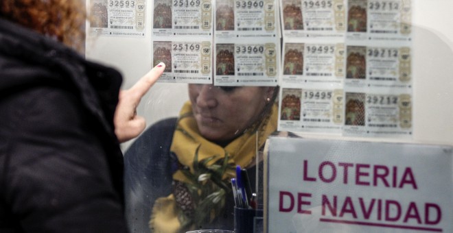 Una mujer escoge un décimo en una administración de Lotería en Valencia. EFE/Manuel Bruque
