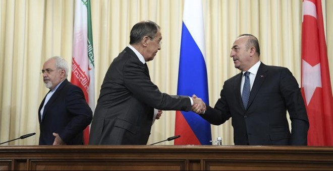 El ministro de Exteriores de Rusia, Serguéi Lavrov, en presencia del ministro de Exteriores iraní, Mohamad Javad Zarif, estrecha la mano de su homólogo de Turquía, Mevlüt Cavusoglu. - EFE