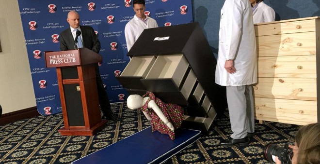 El presidente de la Comisión de Seguridad de los Productos de Consumo de EEUU, Elliot Kaye, observan cómo una cómoda modelo Malm de IKEA cae sobre un muñeco de 13 kilos, en una rueda de prensa en Washington. AFP/Carlos Hamann