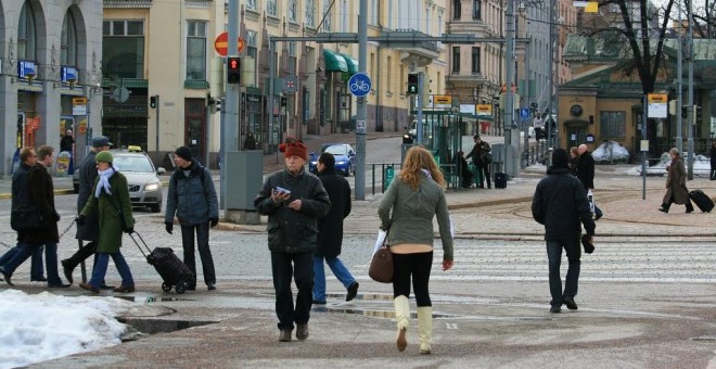 varias personas caminando por una calle de Helsinki.