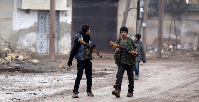 Unos jóvenes portan armas cerca de la ciudad de Alepo el día de Navidad. /REUTERS