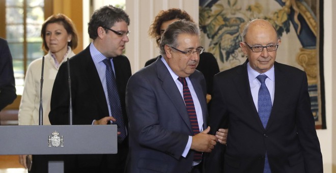 Los ministros de Hacienda, Cristobal Montoro (1d); Interior, Juan Ignacio Zoido (1i); Energía, Turismo y Agenda Digital, Alvaro Nadal (2i), y Defensa, María Dolores de Cospedal (3i), entran en la sala del Palacio de la Moncloa en la que el presidente del