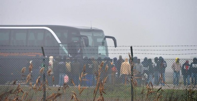Un grupo de inmigrantes se dispone a subir a un autobús antes de abandonar un centro de acogida en la localidad de Cona, en Venecia, para ser trasladados a la región de Emilia-Romaña tras la protesta de anoche por la muerte de Sandrine Bakayoko. EFE