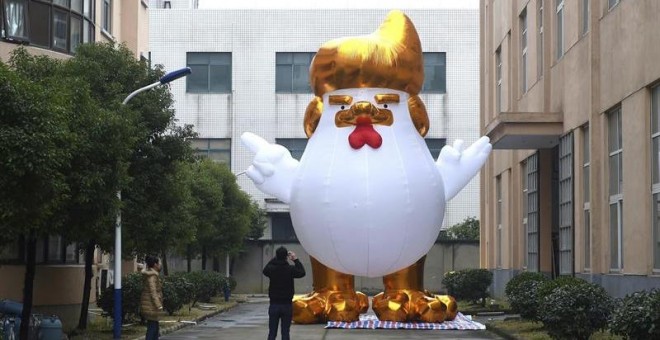 Un hombre hace una foto a una gallina gigante que representa a Donald Trump en una fábrica en Jianxing, en la provincia de Zheijiang (China). - EFE