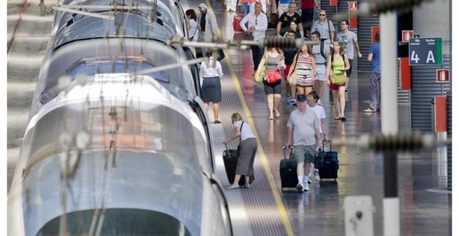 Estación con tren AVE y viajeros de Renfe. E.P.