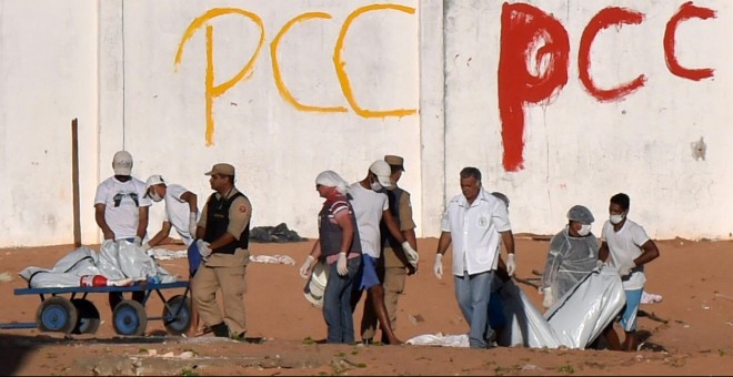 Operarios y policías recogen los cuerpos de presos muertos durante las revueltas en la cárcel de la ciudad de Natal. - REUTERS