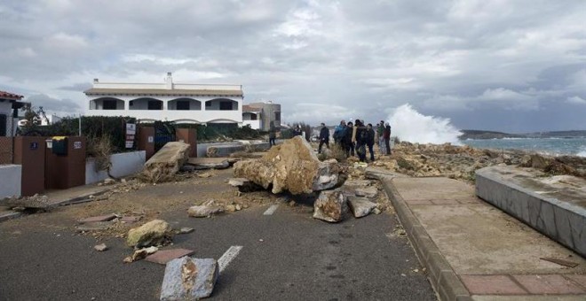 Varias personas observan los destrozos causados por el temporal de mar y viento en la urbanización de S'Algar en el municipio de Sant Lluís, Menorca. - EFE