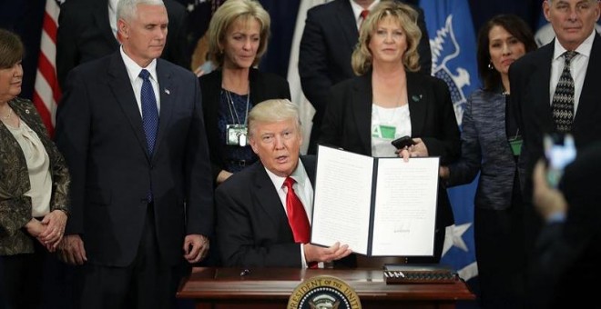 El presidente de EEUU, Donald J. Trump, enseña la firma de la orden ejecutiva para destinar fondos federales a la construcción del muro con México. - EFE