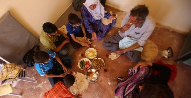 Una familia siria que tuvo que huir de la ciudad de Daraya se reúne para desayunar en una pequeña habitación a las afueras de damasco. - AFP
