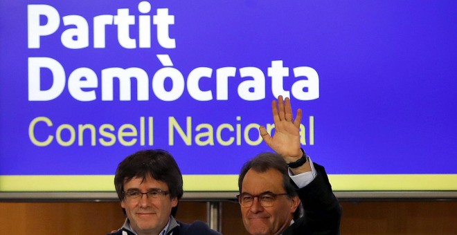 El presidente de la Generalitat, Carles Puigdemont, saluda al expresidente Artur Mas, tras su intervención ante el consell nacional del PDeCat. EFE/Alberto Estévez