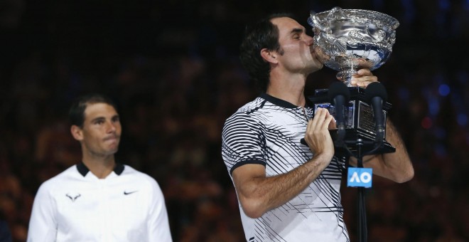 Rafa Nadal observa a Roger Federer besando el trofeo de campeón del Open de Australia. /REUTERS