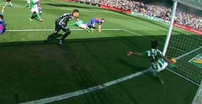 Un defensa del Betis saca el balón de dentro de la portería durante el encuentro ante el Barça.
