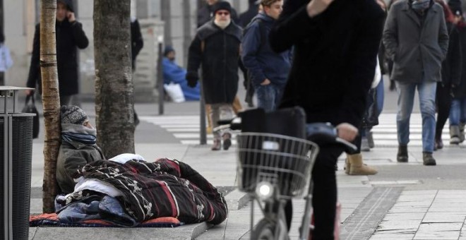 Una persona sin hogar dormita en la calle, en una imagen de archivo. AFP