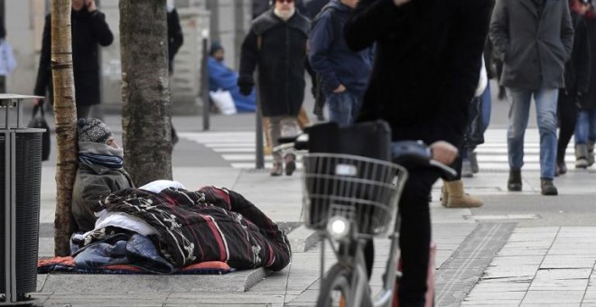 Una persona sin hogar dormita en la calle, en una imagen de archivo. AFP