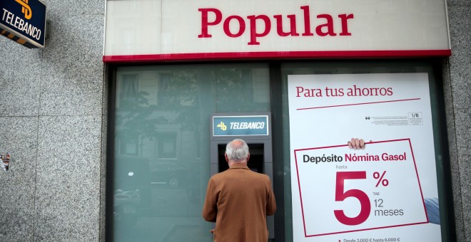 Un hombre utiliza un cajero de una oficina del Banco Popular en Madrid. REUTERS/Andrea Comas