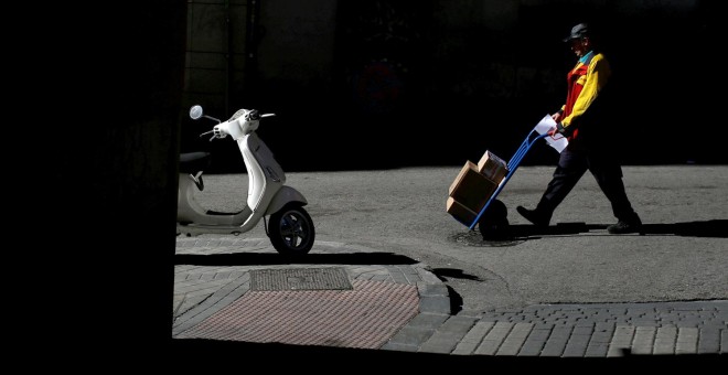 Un repartidor durante su jornada de trabajo en Madrid.-  REUTERS/Juan Medina