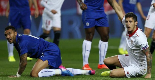 El delantero montenegrino del Sevilla Stevan Jovetic (d) protesta durante el partido de octavos de final de la Liga de Campeones contra el Leicester. | JOSÉ MANUEL VIDAL (EFE)