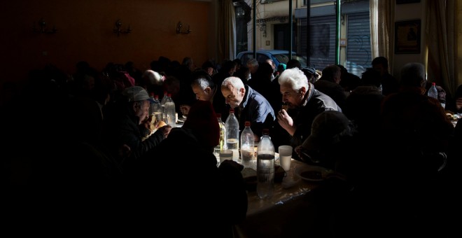 Varias personas tomando sopa de pollo en un comedor benéfico de la Iglesia Ortodoxa griega en Atenas. REUTERS/Alkis Konstantinidis
