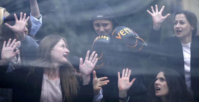 Varias mujeres simulan la ruptura del famoso 'techo de cristal' que rodea a las mujeres con motivo del Día Internacional de la Mujer en Tbilisi, Georgia March. REUTERS/David Mdzinarishvili