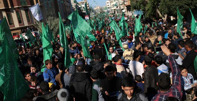 Seguidores del movimiento palestino Hamas con banderas de la organización en la marcha para celebrar el 29 aniversario de su fundación. AFP/Mohammed Abed