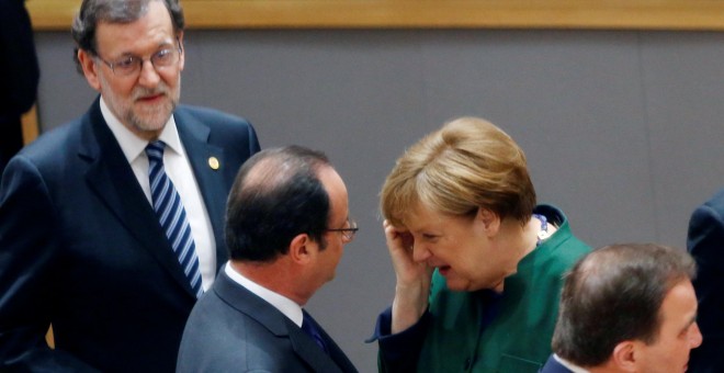 El presidente francés Francois Hollande y la canciller alemana Angela Merkel conversan en presencia del presidente del Gobierno, Mariano Rajoy, durante la cumbre de primavera que se celebra en Bruselas (Bélgica). REUTERS/Francois Lenoir