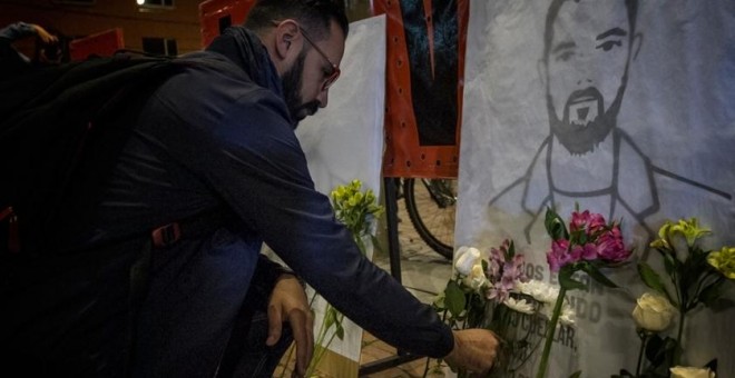 Un hombre coloca flores durante una vigilia en Bogotá, en homenaje a los líderes sociales asesinados en Colombia.- MARCHA PATRIÓTICA