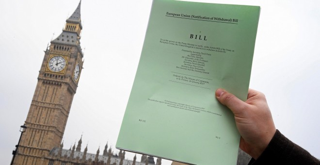 Un periodista posa frente al parlamento británico con una copia del documento del Brexit .REUTERS/Toby Melville