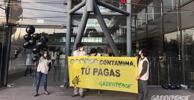 En la sede de Endesa en Madrid los escaladores encaramados en el edificio con la pancarta 'Endesa contamina, tú pagas'. / GREENPEACE