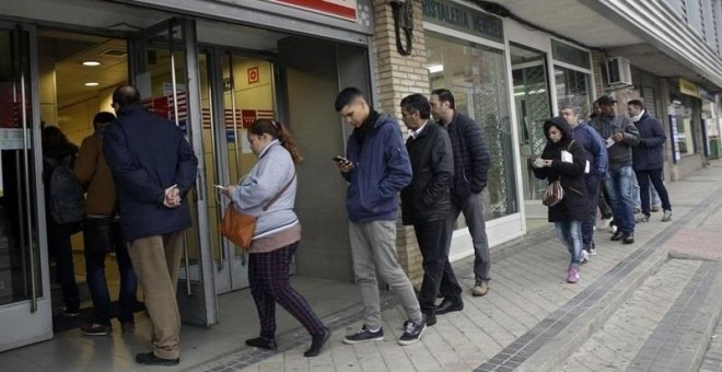 Personas esperando para entrar en una oficina de empleo de la Comunidad de Madrid.
