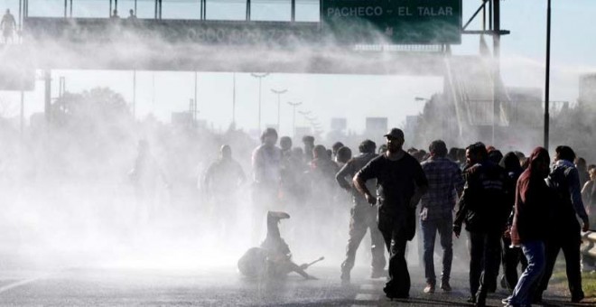 Varios manifestantes son reprimidos con mangueras de agua durante la jornada de huelga general en Argentina. | REUTERS