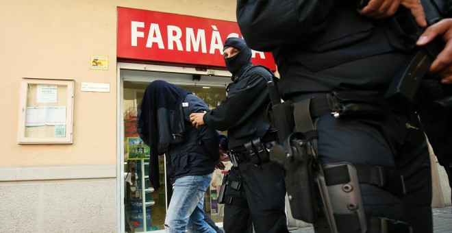 Uno de los detenidos es llevado por los agentes tras la operación antiyihadista en Barcelona.- REUTERS