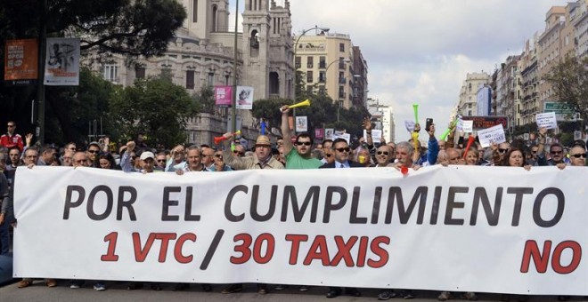 Decenas de taxistas portan una pancarta durante la manifestación hoy en la madrileña calle Raimundo Fernández Villaverde. EFE/Víctor Lerena