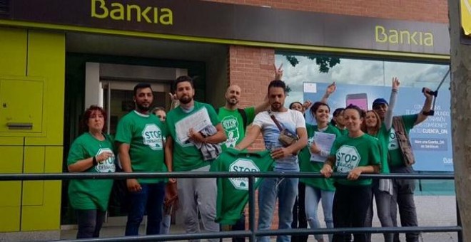 Activistas de la PAH Vallekas, frente a una sucursal de Bankia, tras un encierro para exigir la paralización de cuatro desahucios.- PAH VALLEKAS