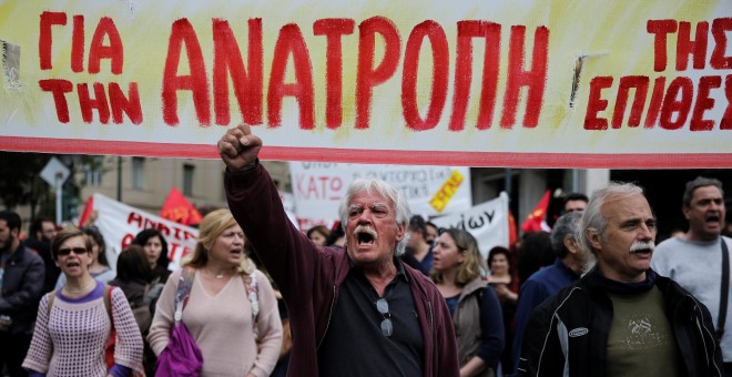 Manifestantes marchan ´con una pancarta en la que se lee 'Subversión' en la protesta convocada la huelga general contra los últimos recortes pactados con la UE. REUTERS/Alkis Konstantinidis