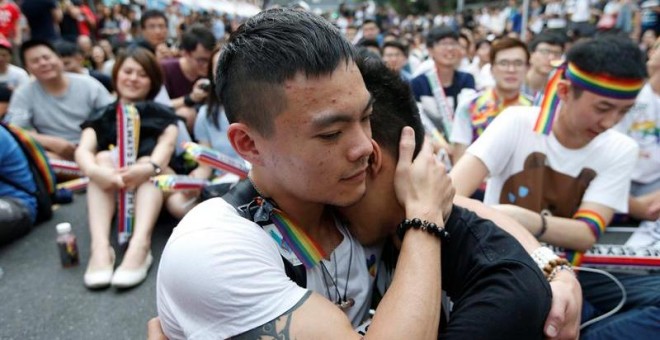 Dos integrantes de la comunidad LGBT (lesbianas, gais, bisexuales y transexuales) se abrazan mientras celebran la decisión del Tribunal Constitucional sobre el matrimonio entre personas del mismo sexo ante el Parlamento en Taipei / EFE