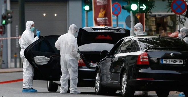 Los forenses inspeccionan el coche del ex primer ministro griego Papademos. REUTERS/Costas Baltas