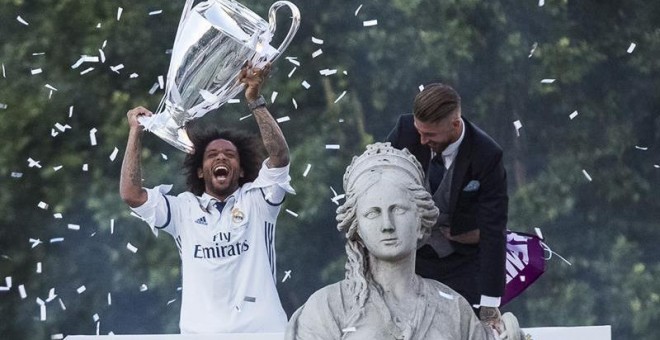 Los jugadores del Real Madrid, Sergio Ramos (d) y el brasileño Marcelo, durante la visita del equipo blanco a la madrileña plaza de Cibeles para celebrar con los aficionados madridistas el titulo de Liga de Campeones. EFE/Santi Donaire.