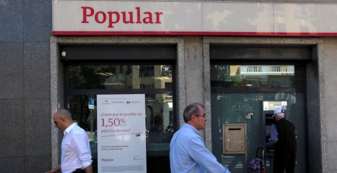 Varios transeuntes pasan junto a una oficina del Banco Popular en Madrid. REUTERS/Juan Medin